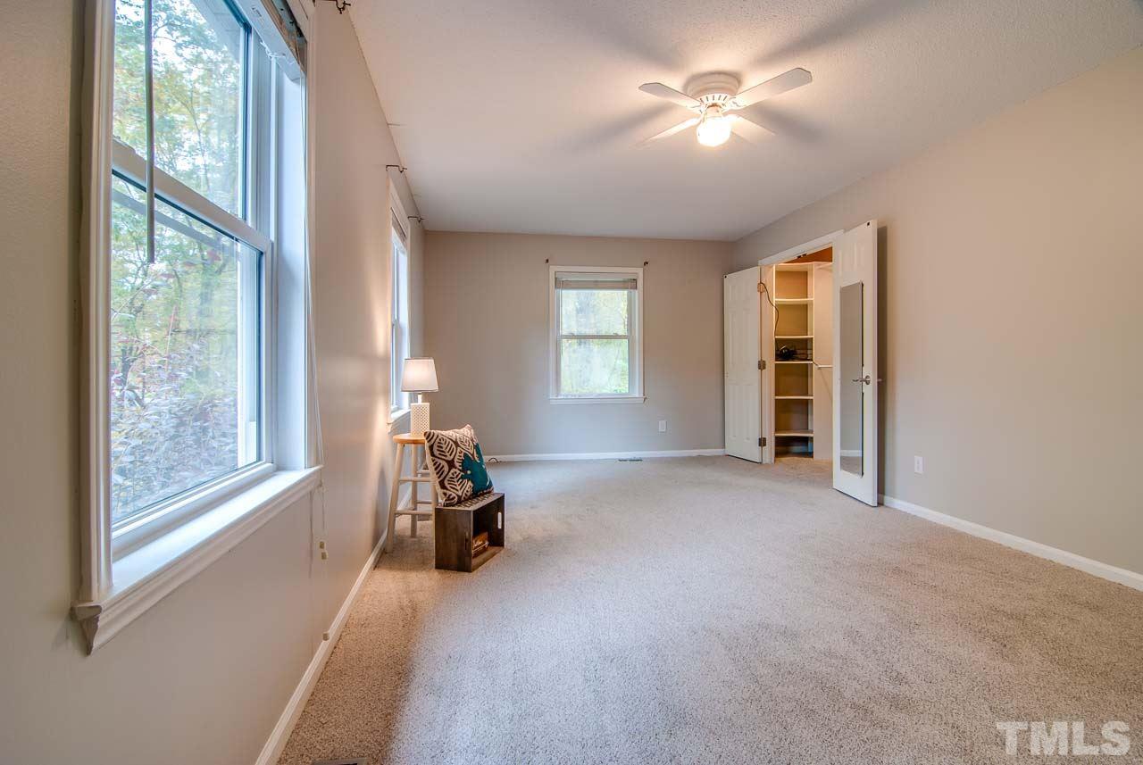 4620 Jimmy Rogers Road Durham, NC 27704 - Photo 16 of 25 an empty room with windows and ceiling fan view