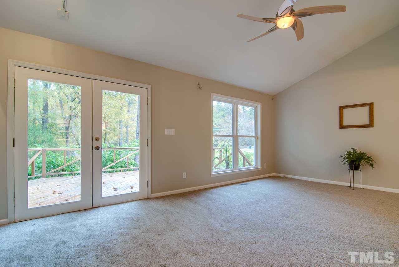 4620 Jimmy Rogers Road Durham, NC 27704 - Photo 3 of 25 a view of a big room with windows and chandelier fan