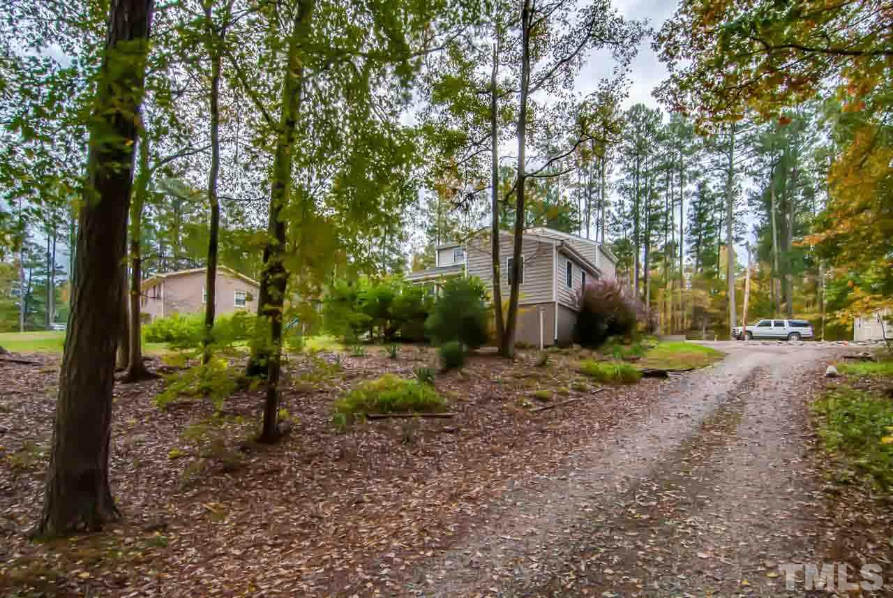4620 Jimmy Rogers Road Durham, NC 27704 - Photo 23 of 25 a backyard of a house with plants and large tree