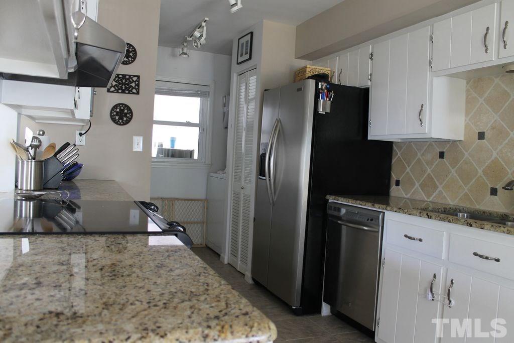 4620 Jimmy Rogers Road Durham, NC 27704 - Photo 7 of 25 a kitchen with stainless steel appliances granite countertop a refrigerator a stove and a sink