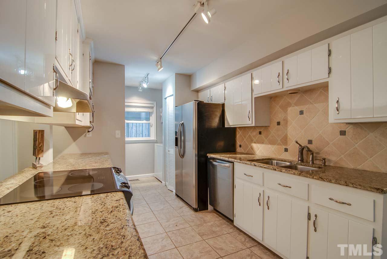 4620 Jimmy Rogers Road Durham, NC 27704 - Photo 9 of 25 a kitchen with a sink dishwasher a refrigerator and cabinets