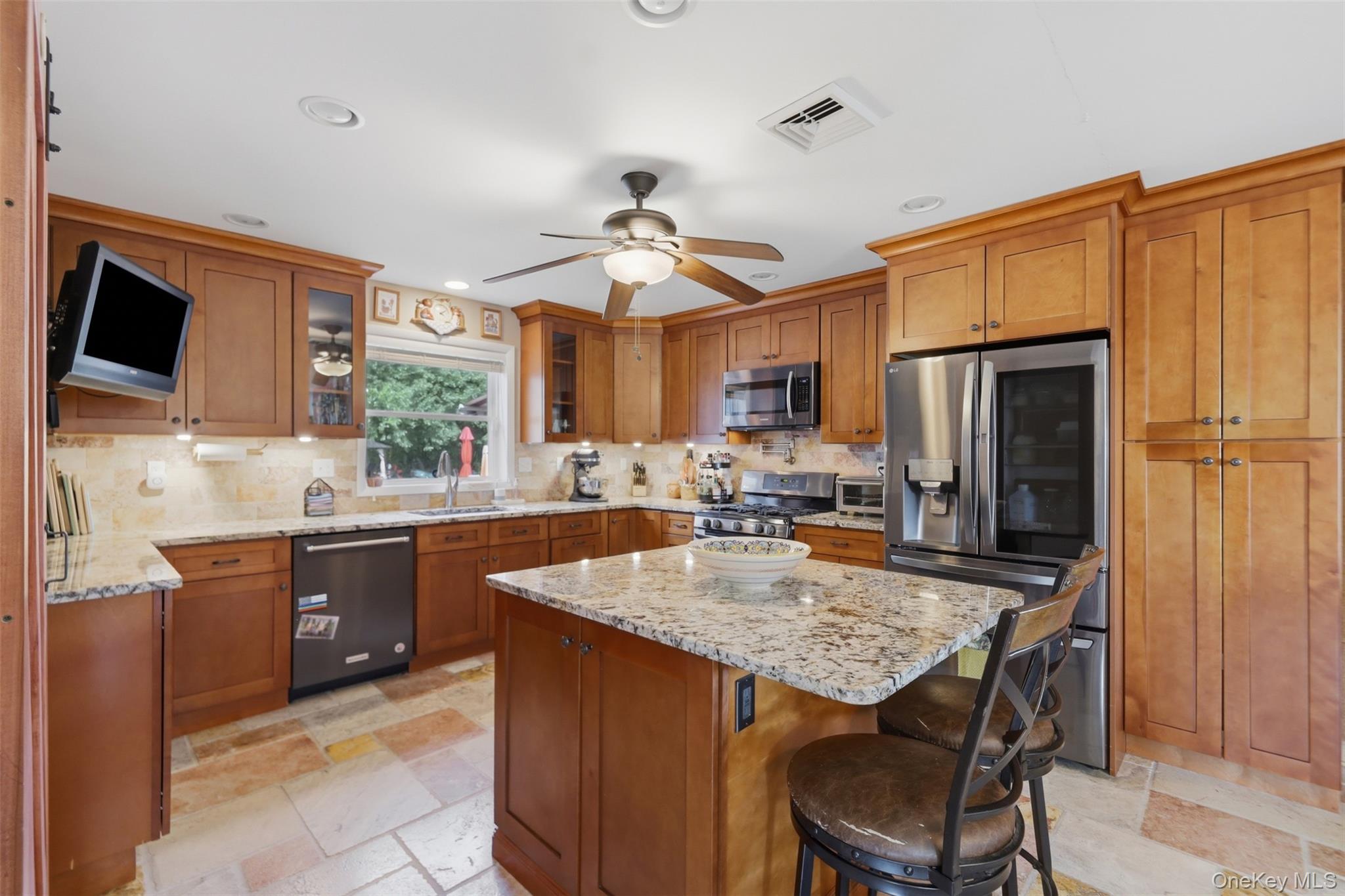 1 Hiko Place Fishkill, NY 12524 - Photo 12 of 41 Kitchen featuring an island with a stone countertop, extensive wood cabinetry, stainless steel appliances, tile flooring, and recessed lighting