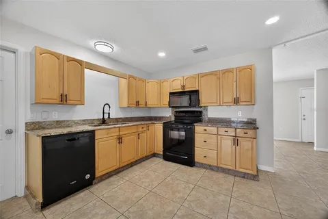 a kitchen with granite countertop appliances cabinets and a sink