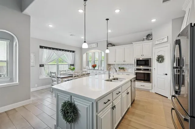 a large kitchen with stainless steel appliances kitchen island a large counter tops and a view of living room