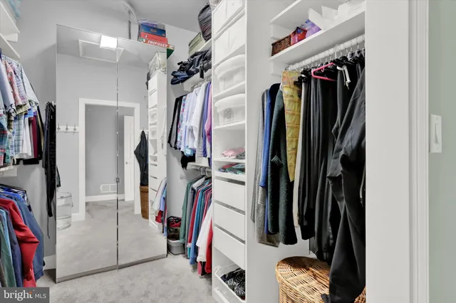 a view of walk in closet with clothes and shoes