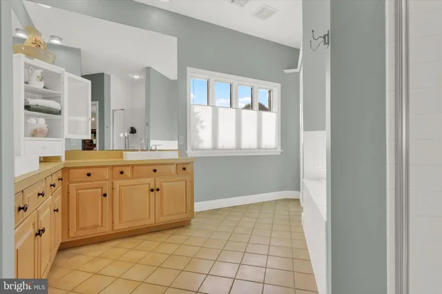 a spacious bathroom with a mirror a sink and a shower