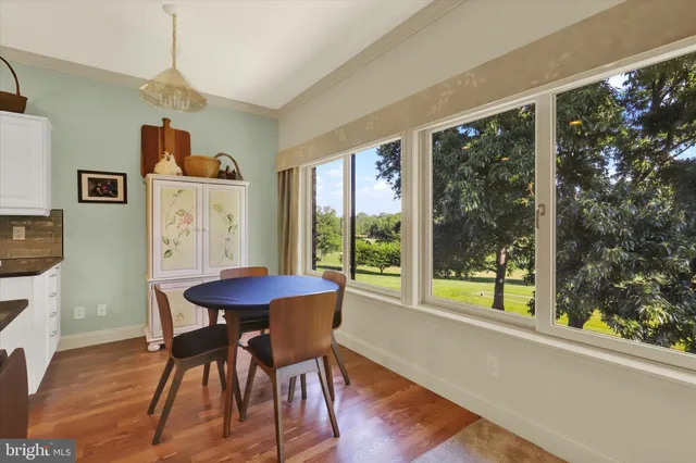 a dining room with furniture a chandelier and wooden floor