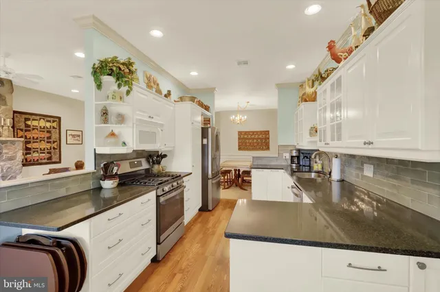a kitchen with stainless steel appliances granite countertop a sink a stove counter space and cabinets