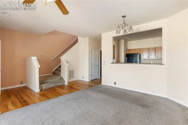 a view of a livingroom with wooden floor and a ceiling fan