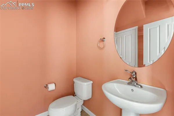 a bathroom with a toilet a sink and mirror