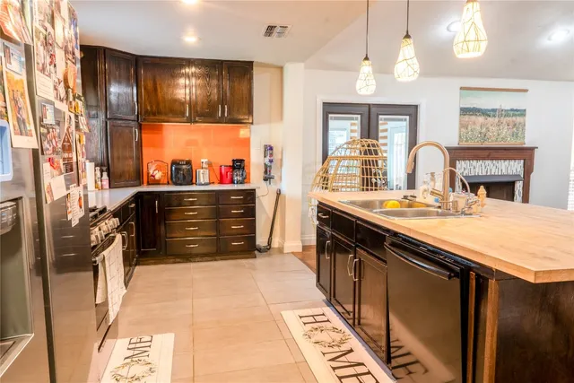 a kitchen with stainless steel appliances kitchen island granite countertop a stove a sink and a refrigerator