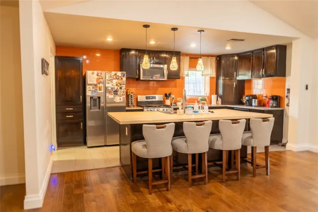 a dining hall with a dining table chairs and white kitchen view