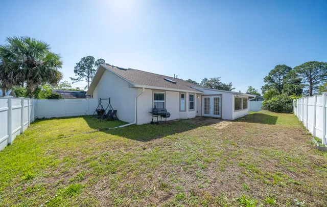 a view of a house with backyard and trees