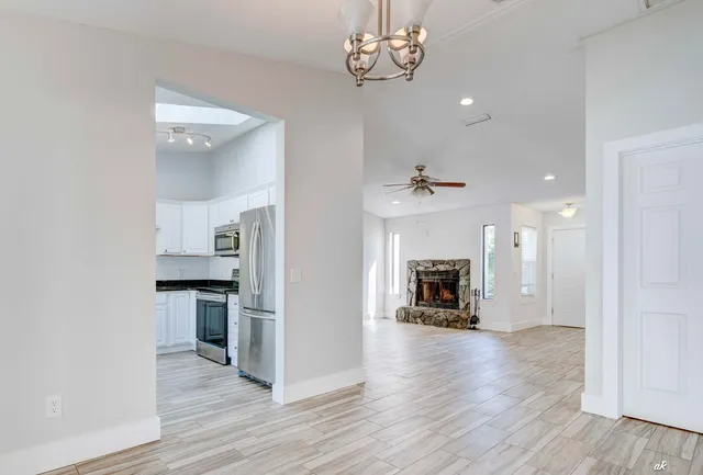a view of a livingroom with a chandelier fireplace and wooden floor