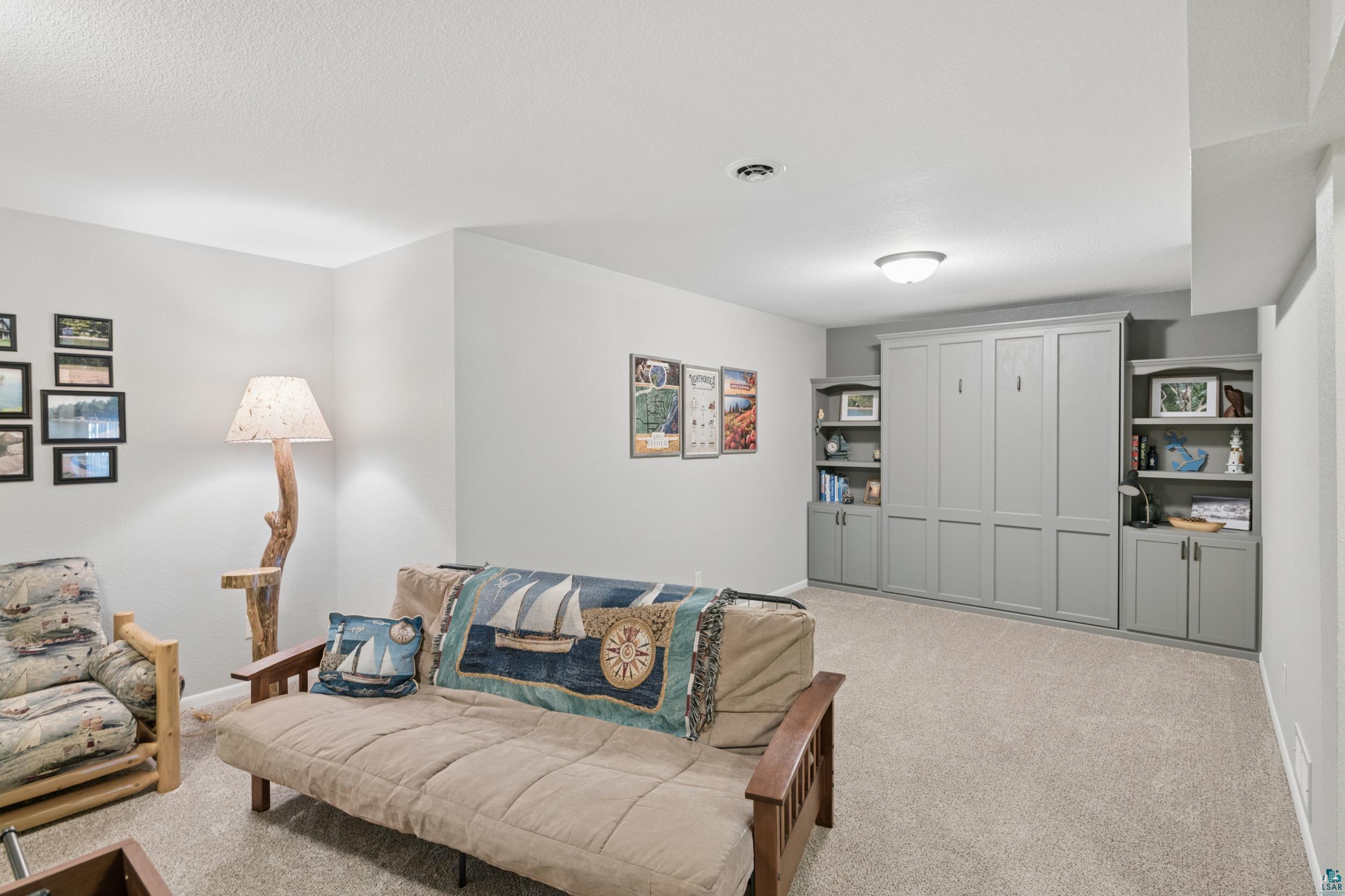34590 Bay View Road, Unit 801 Bayfield, WI 54814 - Photo 21 of 36 Integrated wall unit featuring a Murphy bed, built-in shelving, and lower cabinetry