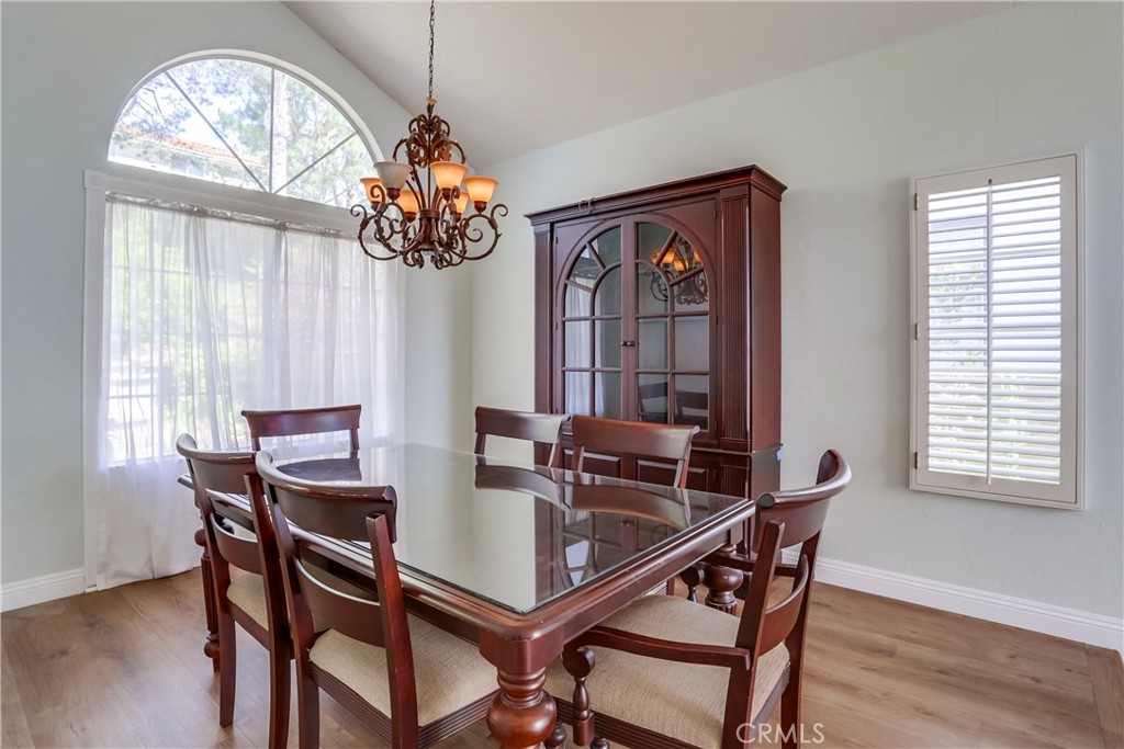 26511 Maside Mission Viejo, CA 92692 - Photo 7 of 46 a dining room with wooden floor a chandelier a wooden table and chairs