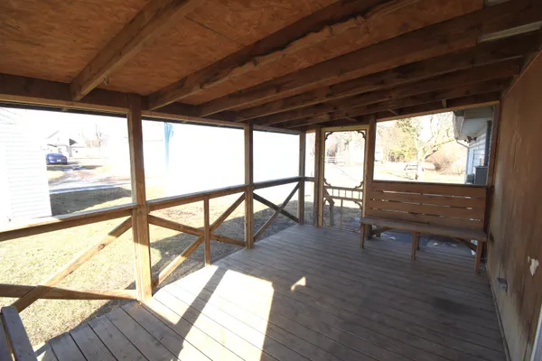 a view of a porch with furniture and wooden floor