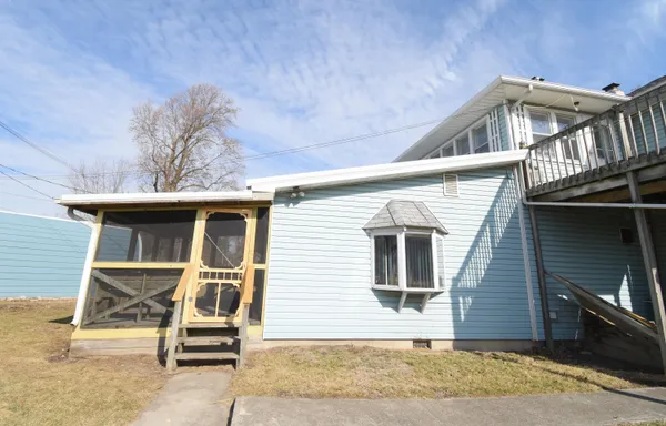 a view of a house with a yard and wooden fence
