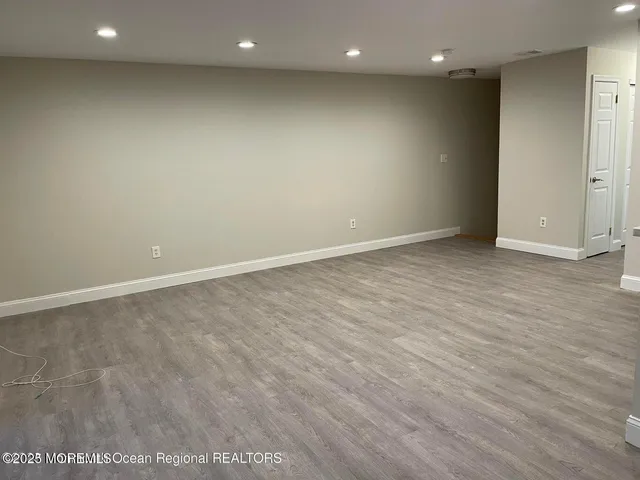 an empty room with wooden floor and entrance