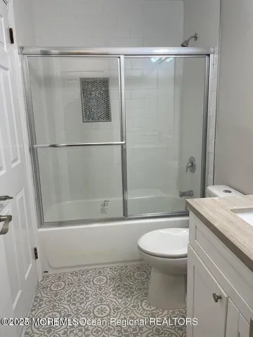 a bathroom with a shower a toilet and a sink