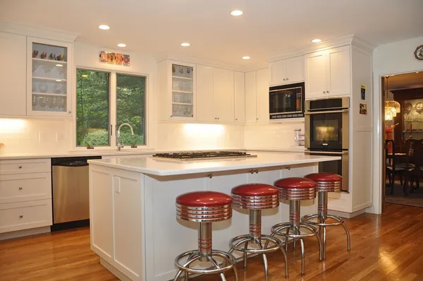 a kitchen with stainless steel appliances granite countertop a stove top oven a sink and a refrigerator