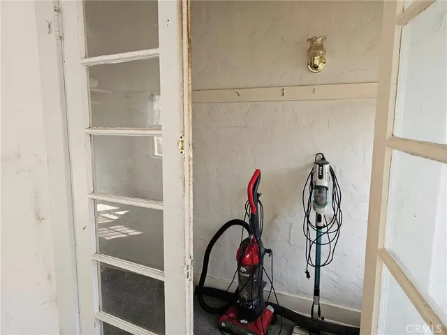 a view of a hallway with wooden floor and a bathroom