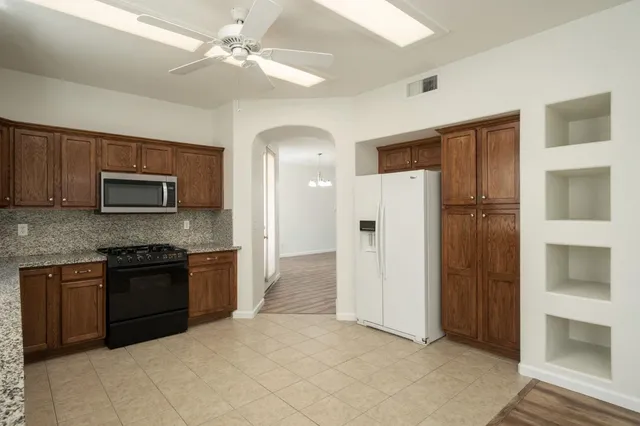 a kitchen with stainless steel appliances granite countertop a refrigerator and a stove top oven