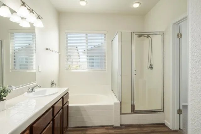 a bathroom with a granite countertop sink a mirror and a bathtub