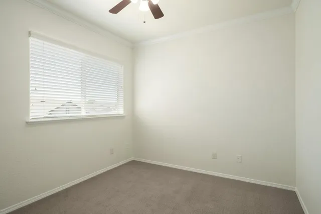 an empty room with a window and a fan