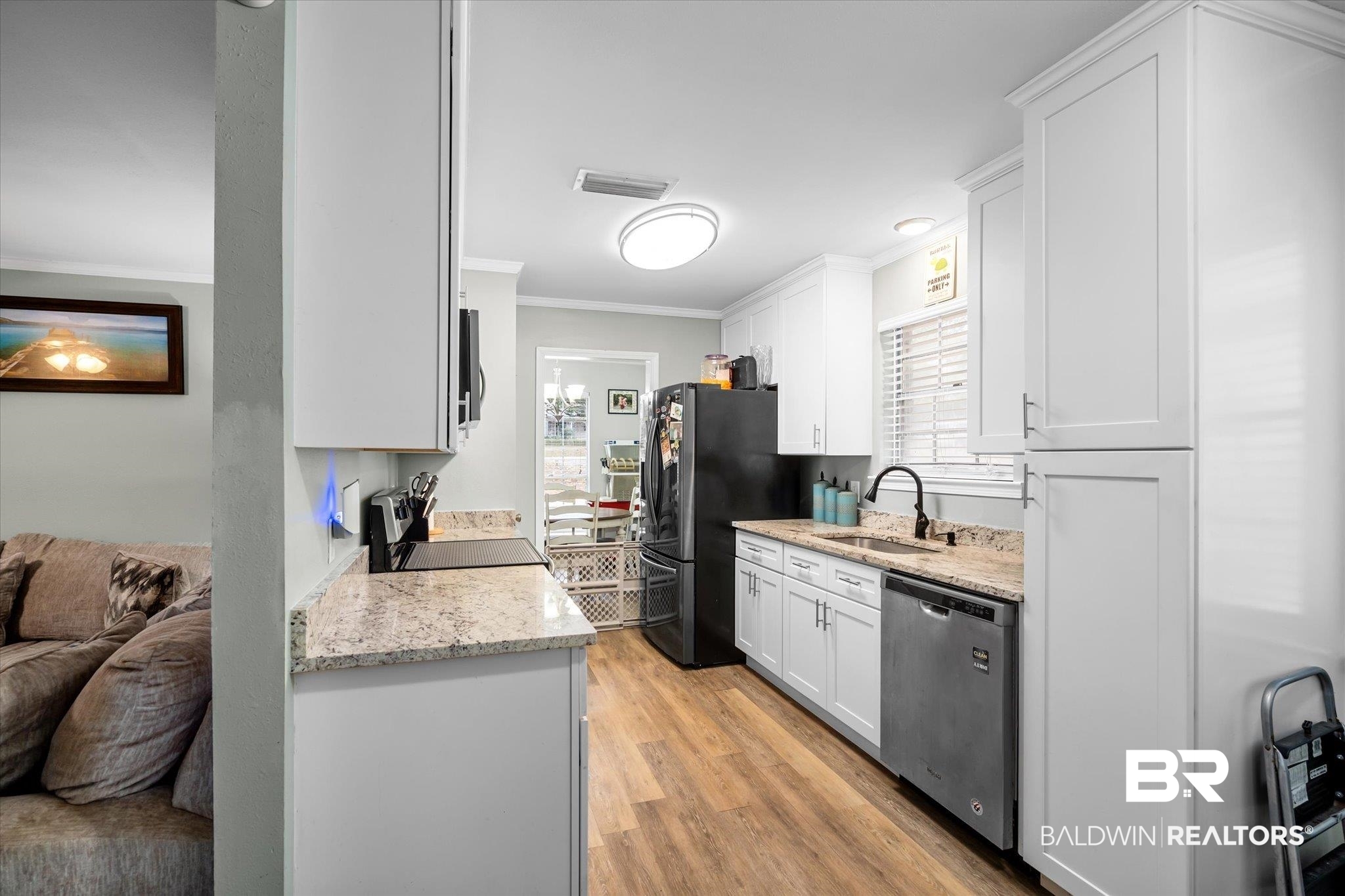 9987 Downing Street Semmes, AL 36575 - Photo 4 of 20 Kitchen featuring appliances with stainless steel finishes, sink, light hardwood / wood-style floors, and white cabinets