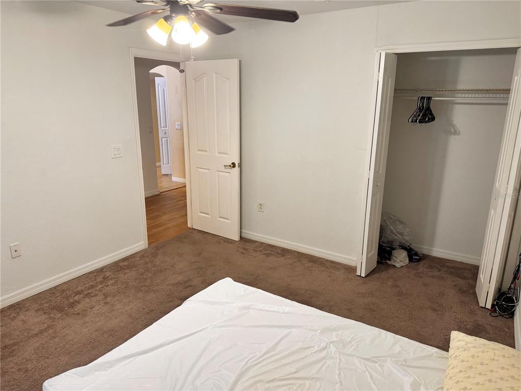 12055 Robina Road Weeki Wachee, FL 34614 - Photo 16 of 64 a bedroom with a bed and a chandelier