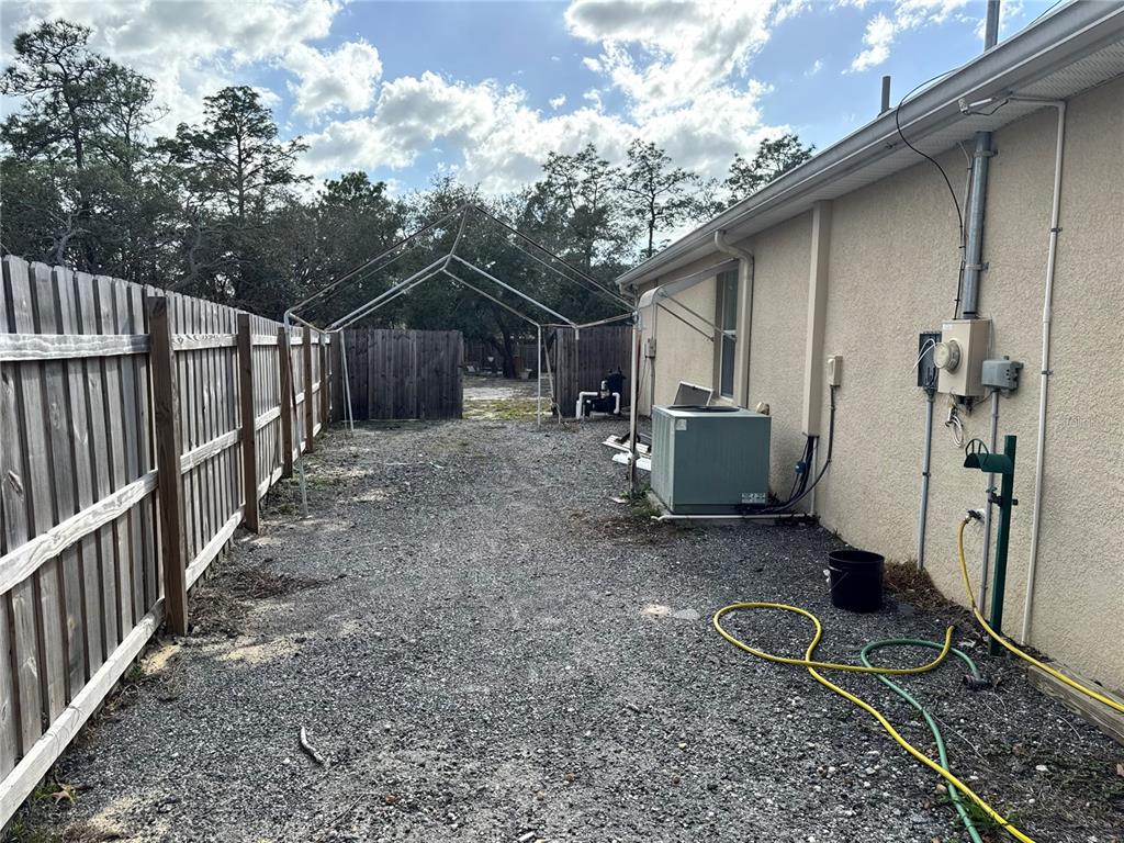 12055 Robina Road Weeki Wachee, FL 34614 - Photo 58 of 64 a view of a backyard with wooden fence and a large tree