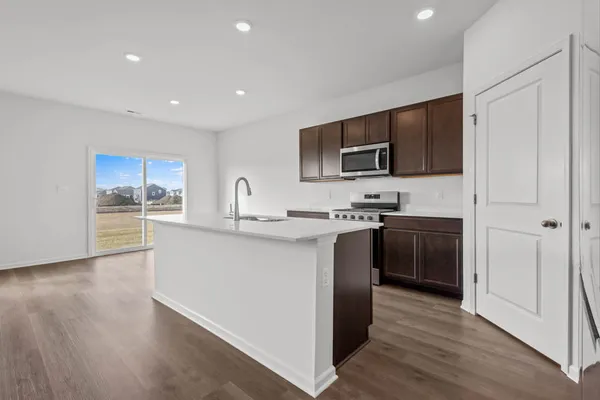 a kitchen with stainless steel appliances granite countertop a sink a stove and a refrigerator