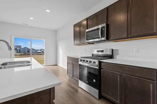 a kitchen with stainless steel appliances granite countertop a stove a sink and a microwave
