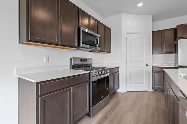 a view of a kitchen with microwave and wooden floor