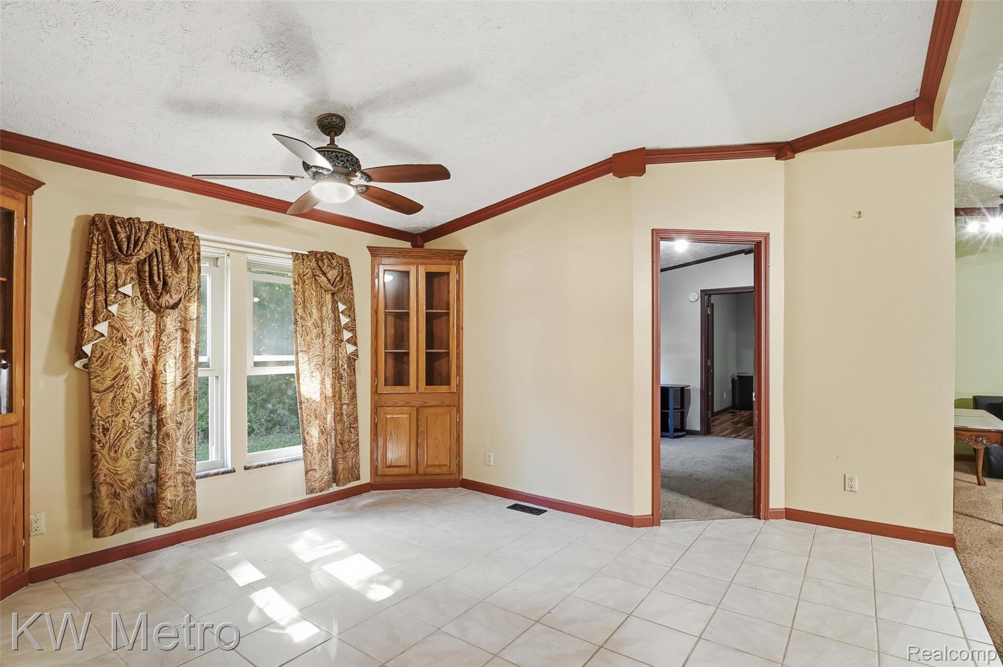 22733 Sumpter Road Belleville, MI 48111 - Photo 7 of 52 Spacious room featuring light-toned tile flooring, a ceiling fan, and built-in corner cabinetry