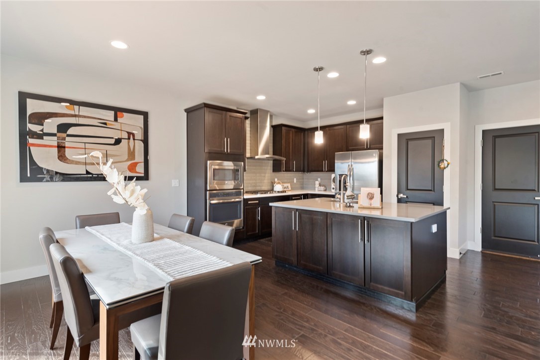20619 3rd Avenue Southeast Bothell, WA 98012 - Photo 7 of 28 a kitchen with stainless steel appliances granite countertop a refrigerator a sink dishwasher a stove and a refrigerator with wooden floor