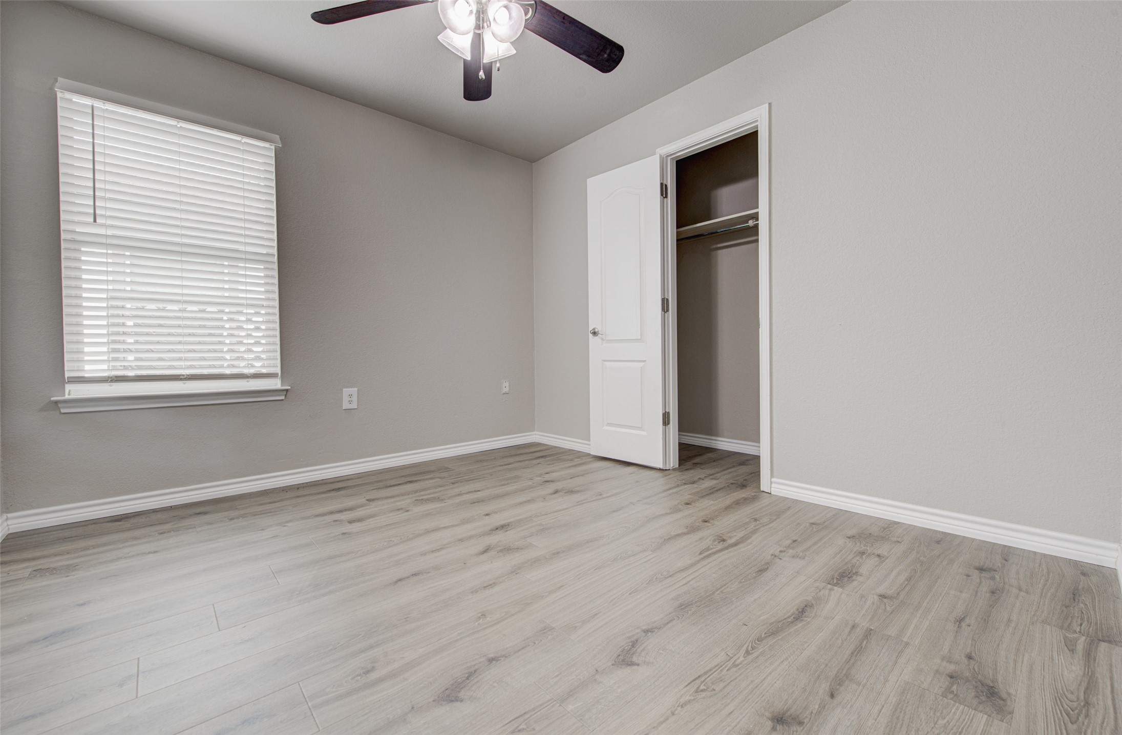 6709 Doyal Drive Austin, TX 78747 - Photo 11 of 22 Unfurnished bedroom with light wood-style floors, a ceiling fan, and a closet