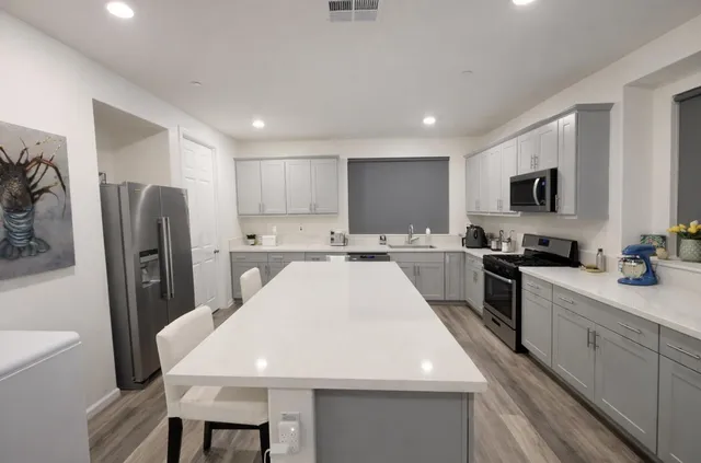 a kitchen with stainless steel appliances a refrigerator sink and microwave