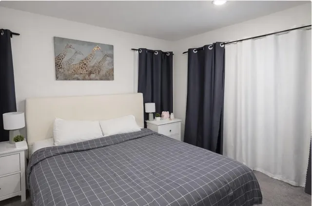 a bedroom with a large bed and a large mirror