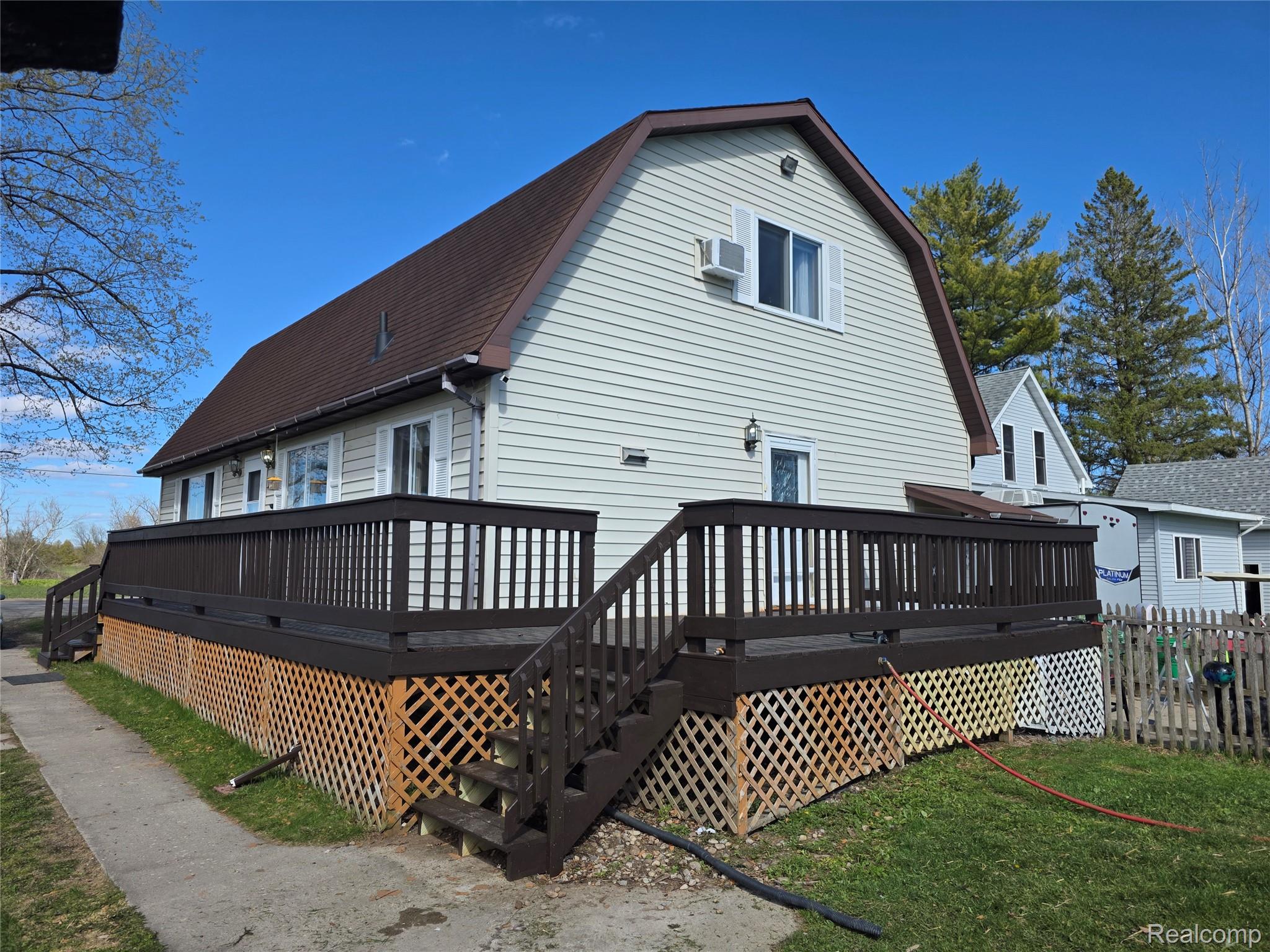 5847 F Road Bark River, MI 49807 - Photo 1 of 25 Rear view of property with a gambrel roof, a wooden deck, and roof with shingles