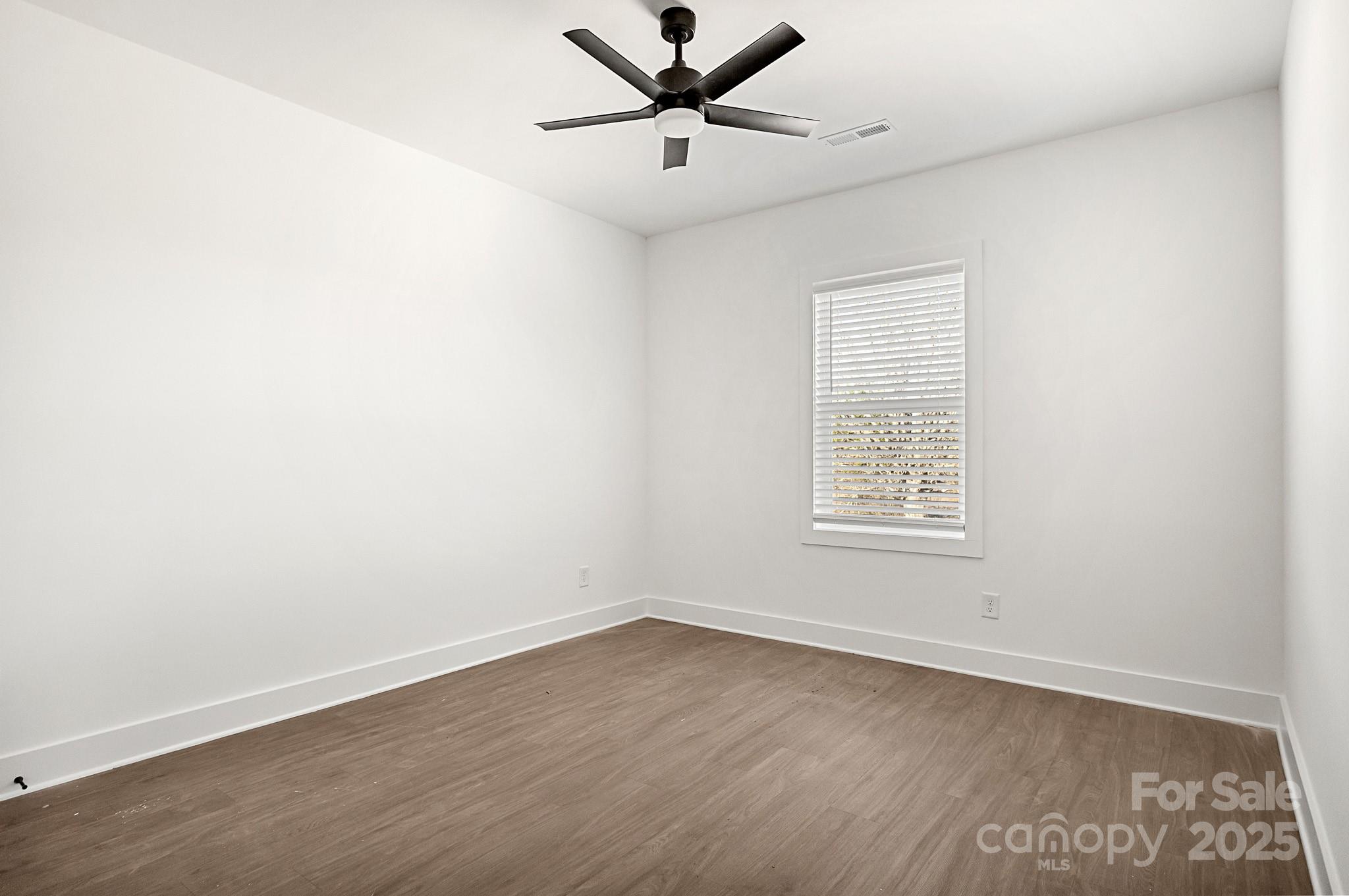 3309 Old Pageland Monroe Road Monroe, NC 28112 - Photo 26 of 37 an empty room with wooden floor ceiling fan and windows
