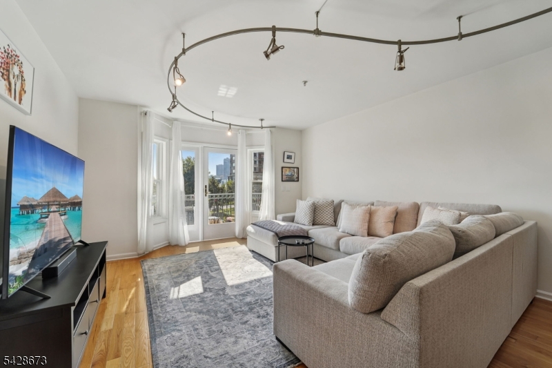 129 The Promenade Edgewater, NJ 07020 - Photo 2 of 17 a living room with furniture and a flat screen tv