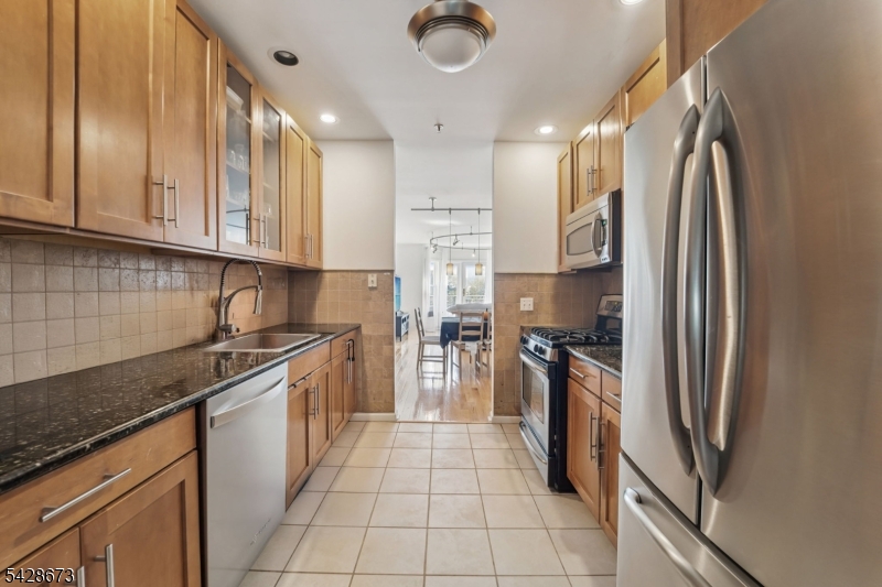 129 The Promenade Edgewater, NJ 07020 - Photo 4 of 17 a kitchen with stainless steel appliances granite countertop a refrigerator a stove and a sink