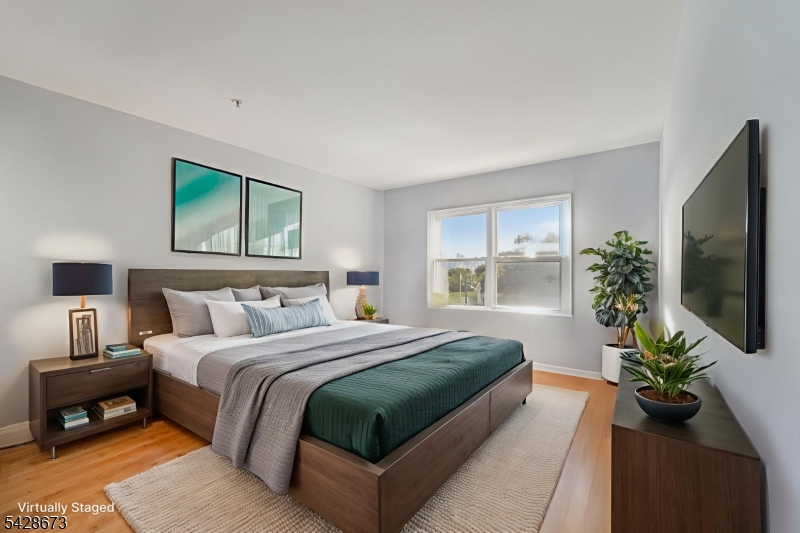 129 The Promenade Edgewater, NJ 07020 - Photo 5 of 17 a bedroom with a large bed and a potted plant