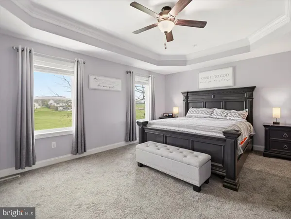 a bedroom with a large bed and a chandelier fan