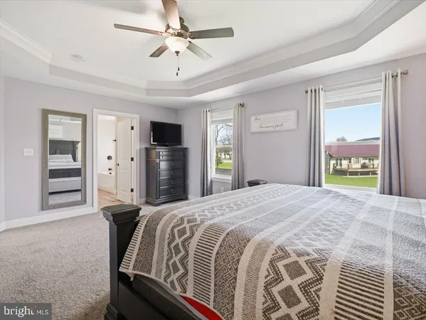 a spacious bedroom with a bed and a ceiling fan