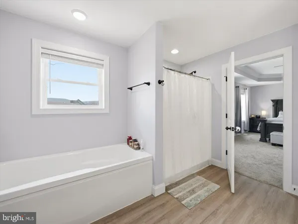 a bathroom with a tub a toilet and a shower