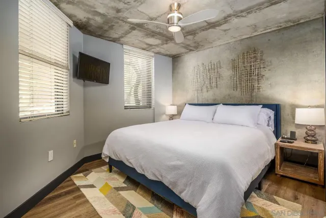 a bedroom with a large bed and a flat tv screen on a dresser