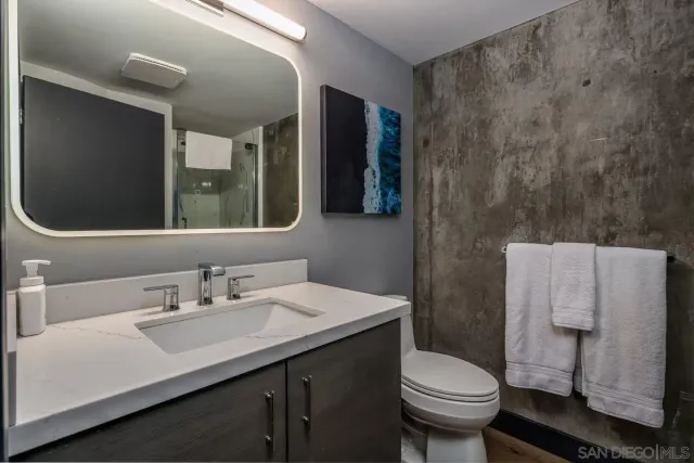 a bathroom with a sink toilet and mirror